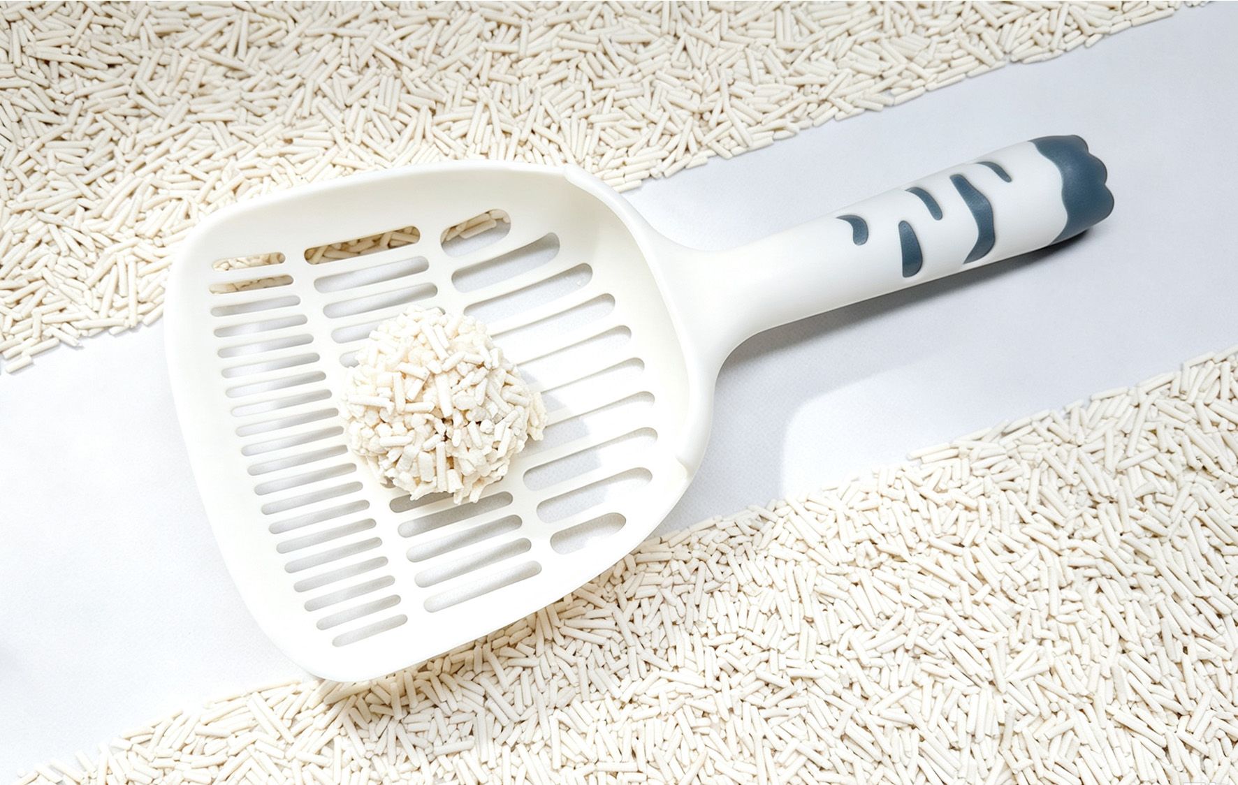 A scoop holding one clump of tofu litter, clean white background